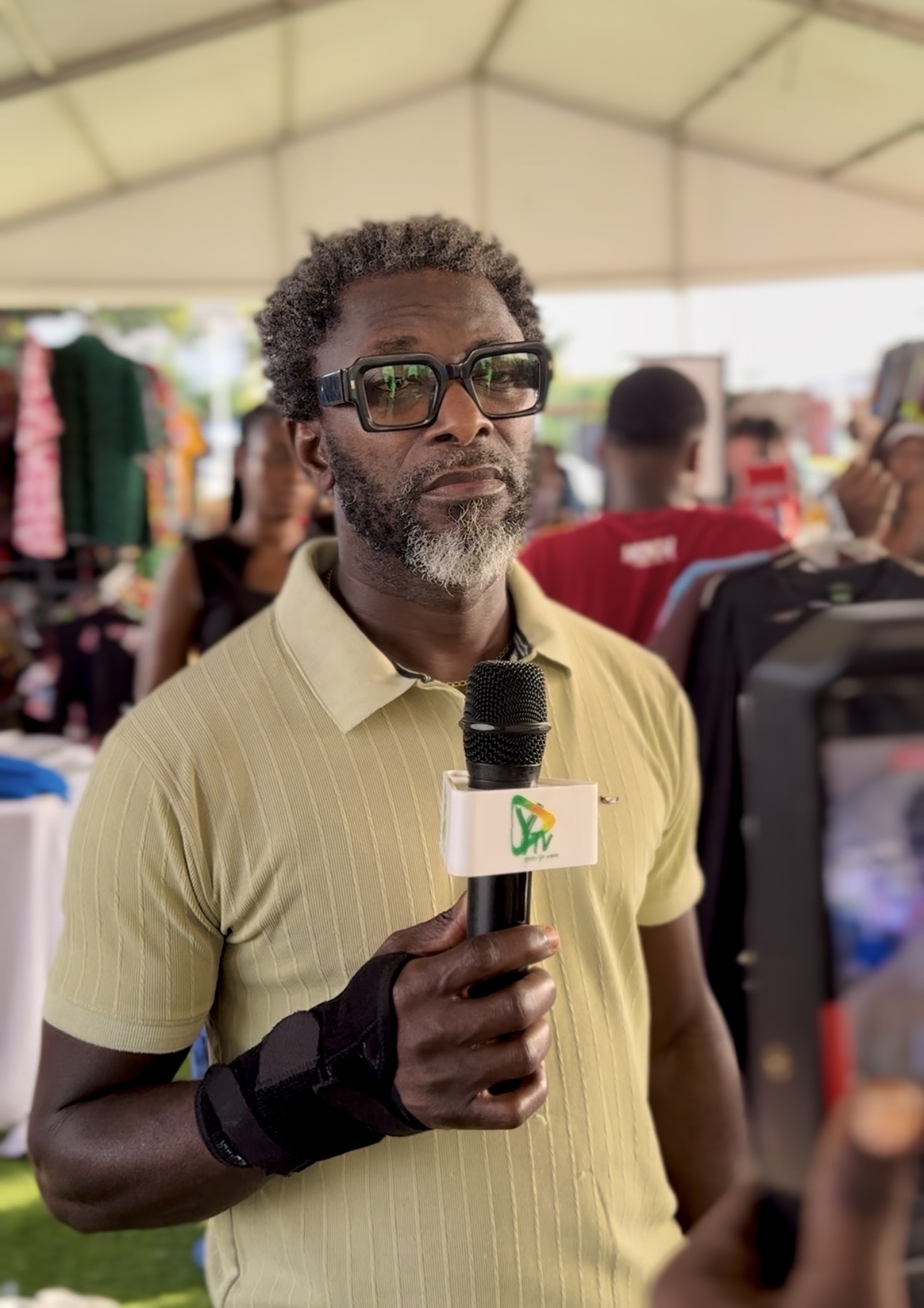 A media presenter interviewing guests live from the Kelphy Sales Fest tent